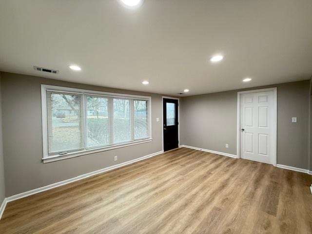 empty room featuring baseboards, visible vents, and wood finished floors