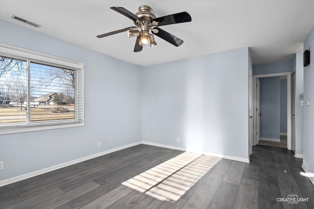 spare room with ceiling fan, wood finished floors, visible vents, and baseboards