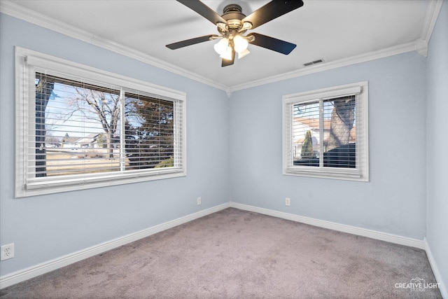 carpeted empty room with ornamental molding, visible vents, baseboards, and a ceiling fan