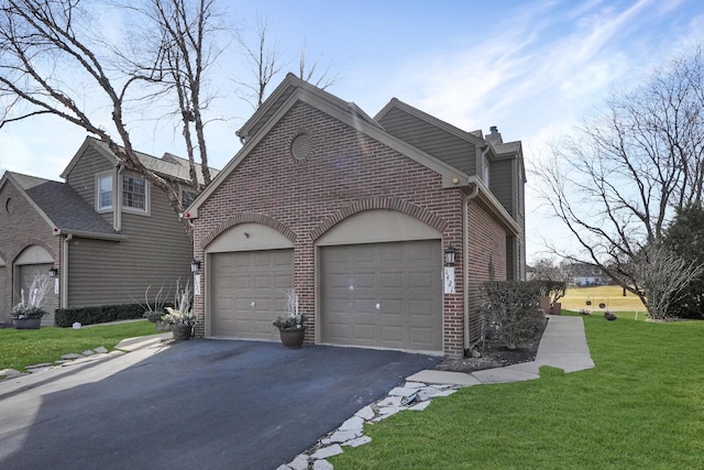 view of home's exterior with aphalt driveway, brick siding, a garage, and a yard