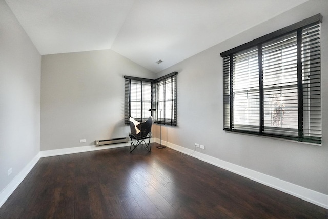 spare room featuring a baseboard heating unit, lofted ceiling, wood finished floors, and baseboards