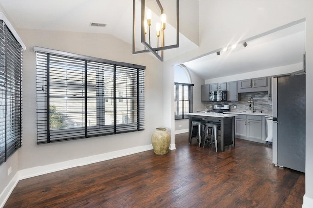 kitchen featuring gray cabinetry, stainless steel appliances, light countertops, and vaulted ceiling