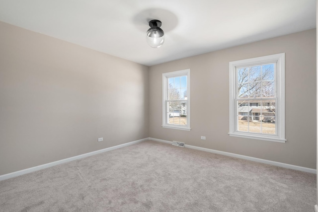 carpeted empty room with visible vents and baseboards