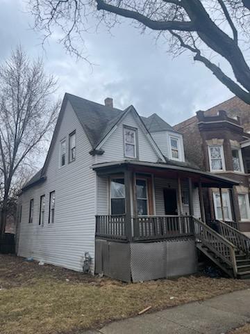 view of front facade with a chimney and a porch