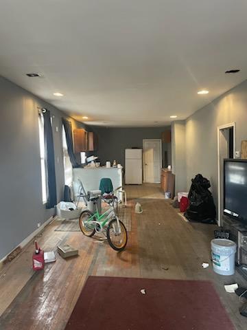 living area with baseboards and wood finished floors