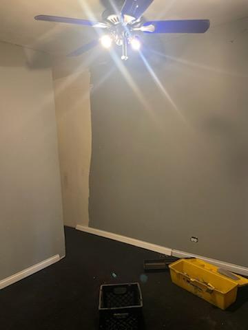 spare room with ceiling fan and baseboards