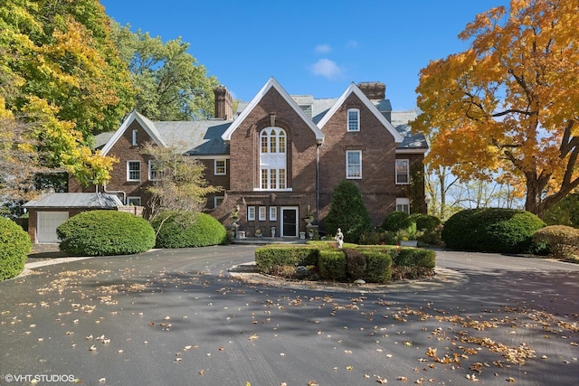 shingle-style home with brick siding and a chimney