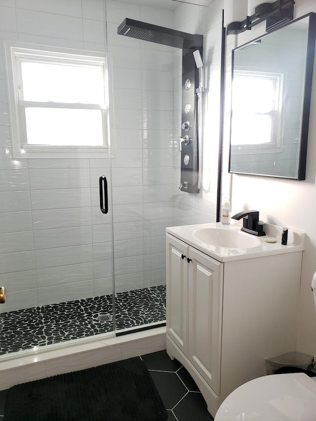 bathroom featuring a stall shower, vanity, toilet, and tile patterned floors