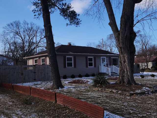 ranch-style house featuring fence and a chimney