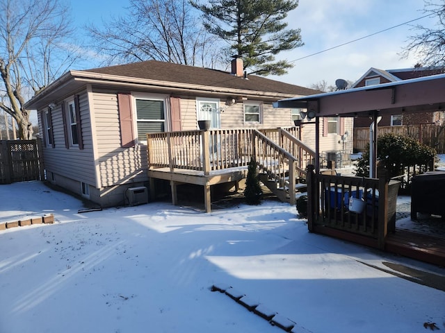 view of front of home featuring a chimney, fence, and a wooden deck