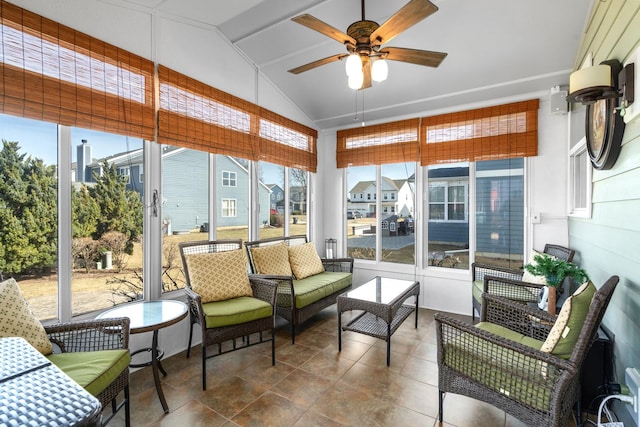 sunroom featuring a residential view, lofted ceiling, and ceiling fan