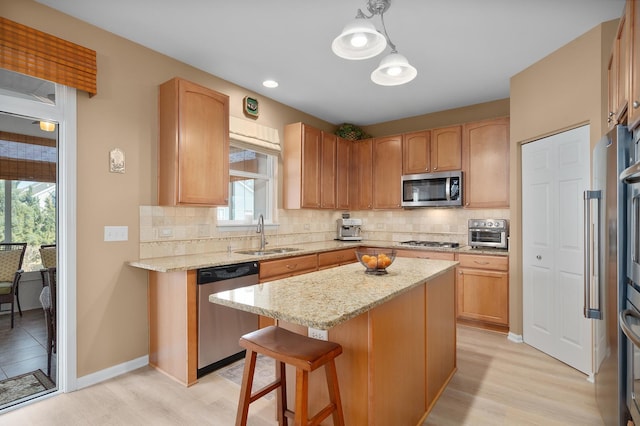 kitchen with light stone countertops, a kitchen island, a sink, decorative backsplash, and stainless steel appliances