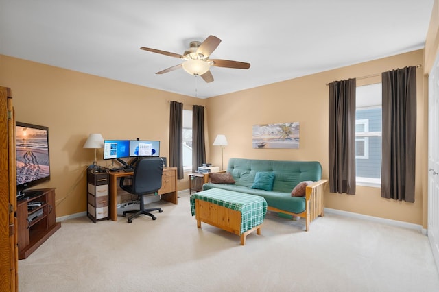 home office featuring baseboards, light colored carpet, and a ceiling fan