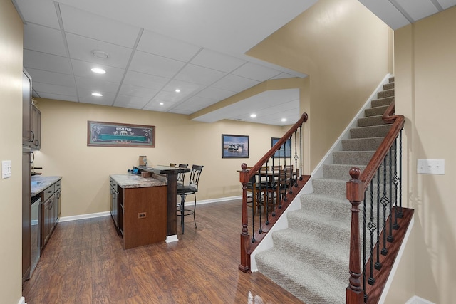 kitchen with recessed lighting, baseboards, dark wood-type flooring, and a breakfast bar