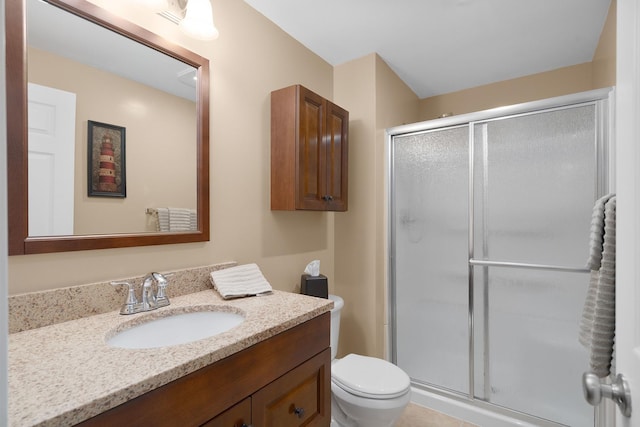 bathroom with toilet, a stall shower, and vanity