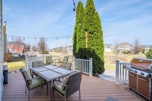 wooden deck featuring a residential view, outdoor dining area, and grilling area