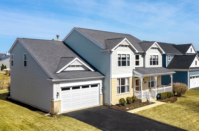 view of front of house featuring driveway, covered porch, a front lawn, and a shingled roof