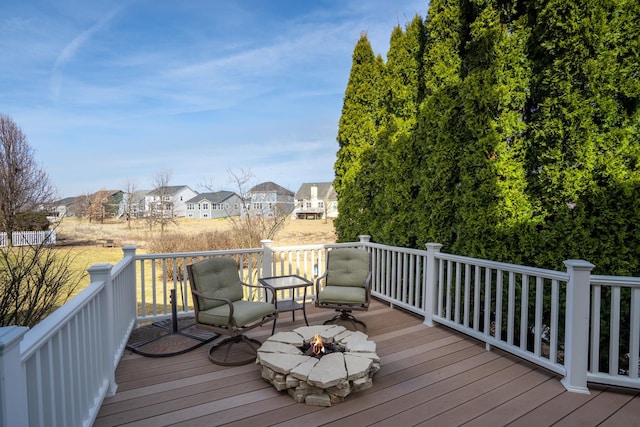 wooden terrace featuring a residential view and a fire pit