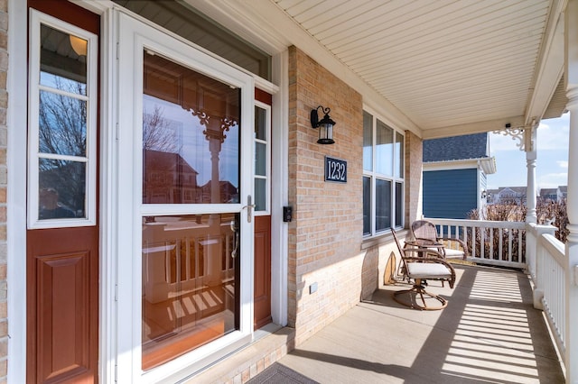 entrance to property with brick siding and covered porch