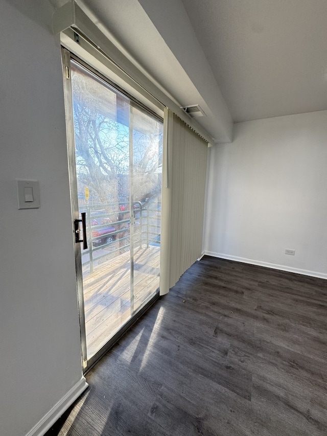 empty room with visible vents, baseboards, and dark wood-style flooring