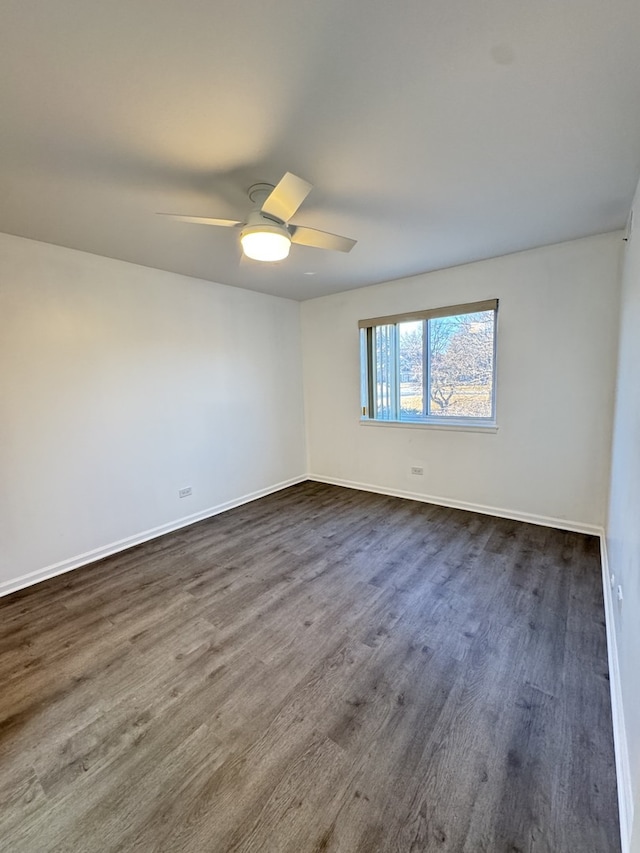 empty room with ceiling fan, baseboards, and dark wood finished floors