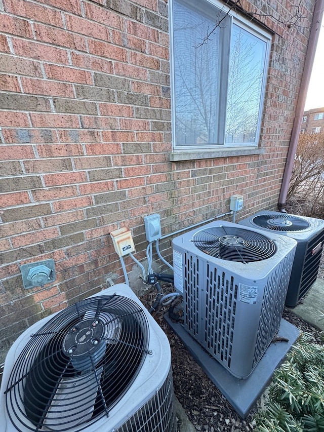 exterior details featuring brick siding and central AC