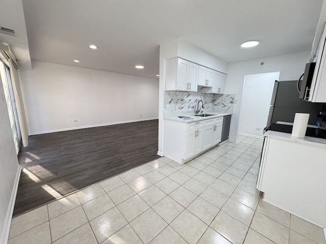 kitchen featuring light tile patterned floors, light countertops, visible vents, decorative backsplash, and a sink