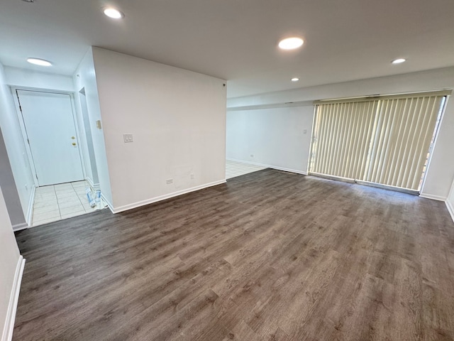 spare room with baseboards, dark wood-type flooring, and recessed lighting