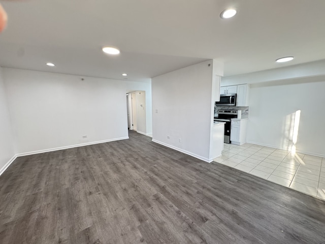 interior space featuring arched walkways, recessed lighting, baseboards, and tile patterned floors