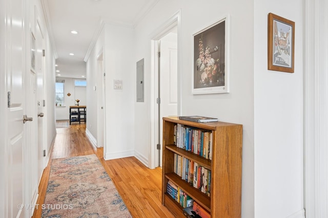 corridor with electric panel, recessed lighting, light wood-style floors, crown molding, and baseboards