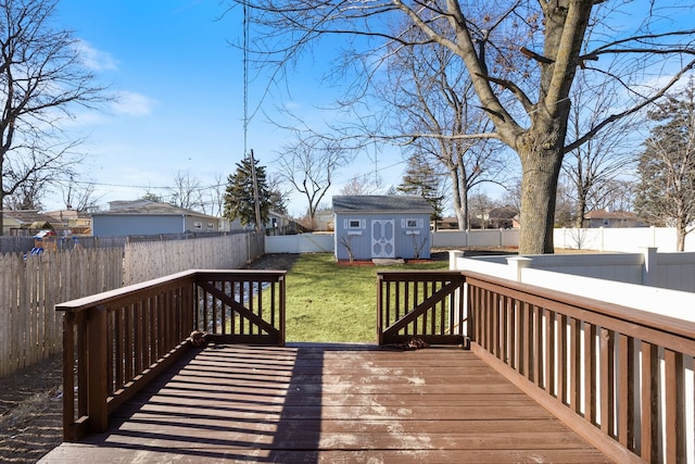 wooden terrace with a storage shed, a lawn, an outdoor structure, and a fenced backyard