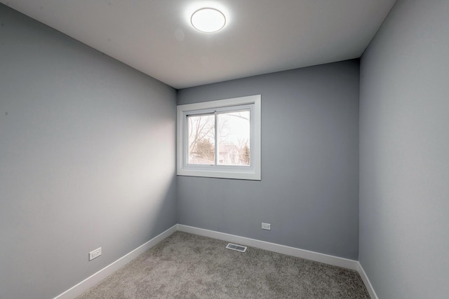 unfurnished room with carpet flooring, visible vents, and baseboards