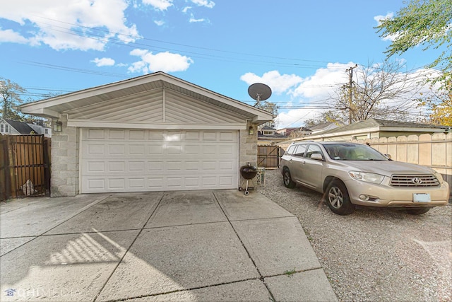 detached garage with a gate and fence