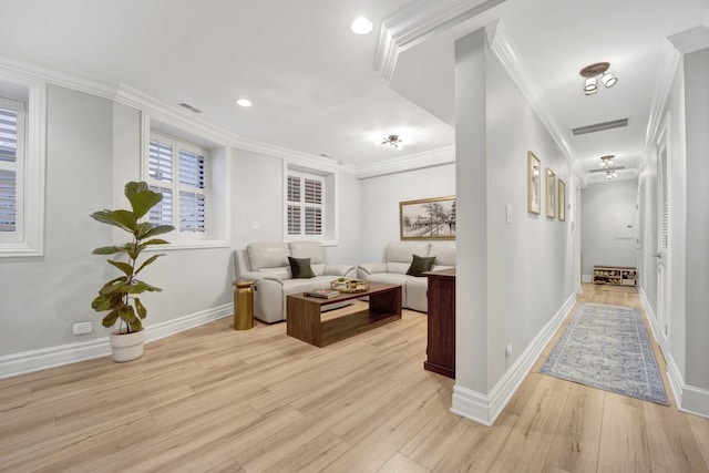 hallway featuring crown molding, visible vents, and light wood-type flooring