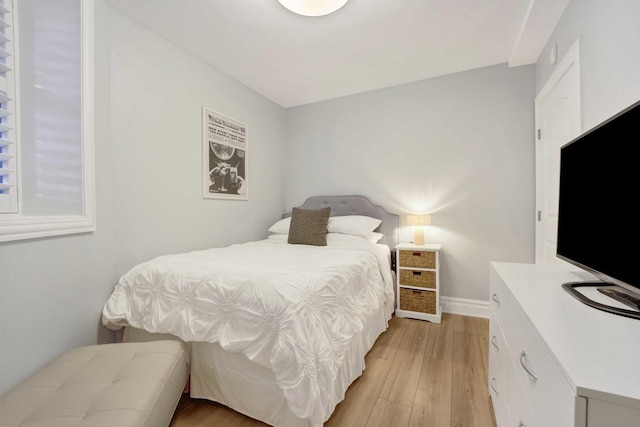 bedroom with baseboards and light wood finished floors