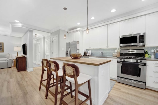 kitchen with a sink, wood counters, backsplash, and appliances with stainless steel finishes