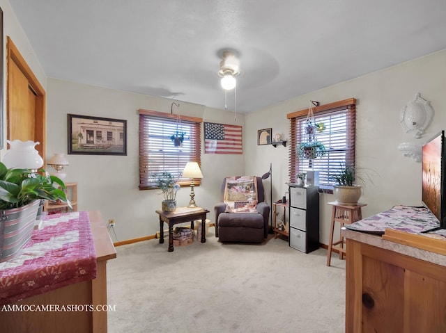 sitting room with baseboards and light colored carpet