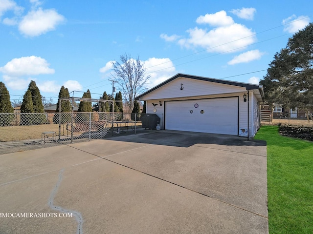 exterior space featuring an outbuilding, fence, a detached garage, and a lawn