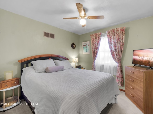 carpeted bedroom featuring visible vents and a ceiling fan