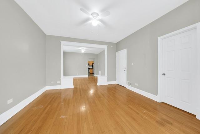 spare room with ceiling fan, light wood-style flooring, and baseboards