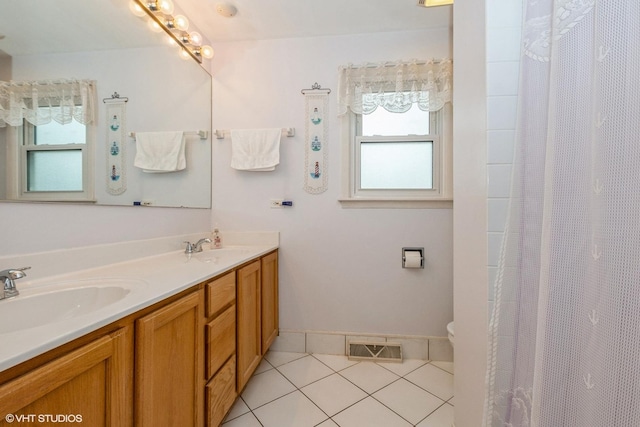 bathroom with plenty of natural light, tile patterned flooring, a sink, and visible vents