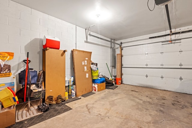 garage with concrete block wall and a garage door opener