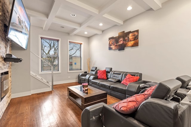 living area featuring a fireplace, hardwood / wood-style floors, coffered ceiling, beamed ceiling, and baseboards