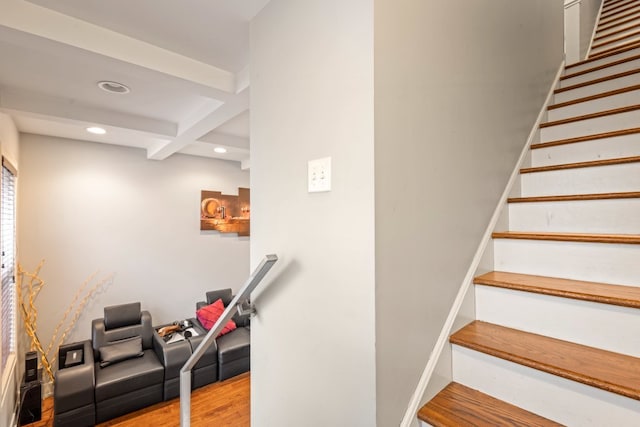 stairs with beam ceiling, coffered ceiling, wood finished floors, and recessed lighting