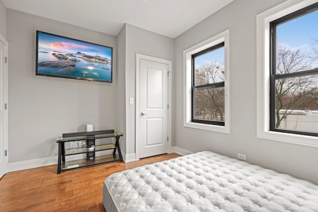 bedroom with baseboards and wood finished floors