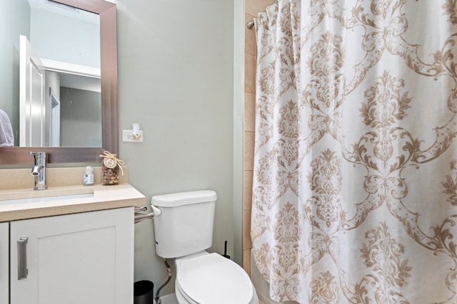 bathroom featuring toilet, a shower with shower curtain, and vanity