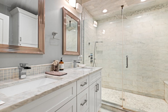 full bath with a sink, a shower stall, decorative backsplash, and double vanity