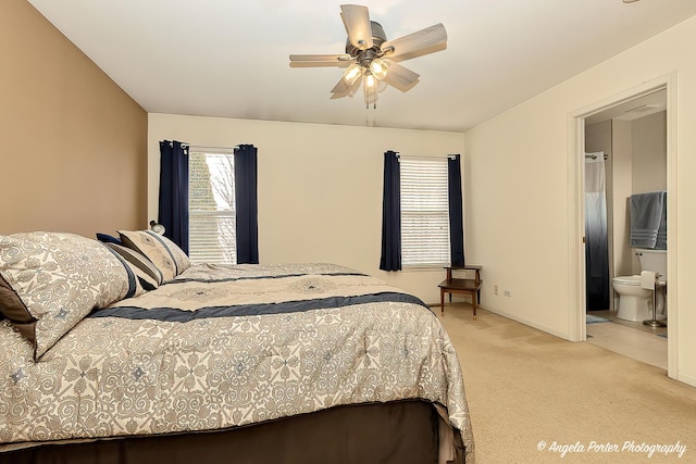 carpeted bedroom with ceiling fan, ensuite bath, and baseboards