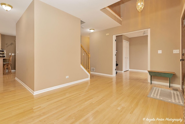 interior space with stairs, light wood-type flooring, visible vents, and baseboards