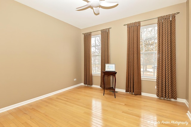 empty room featuring light wood finished floors, visible vents, baseboards, and a ceiling fan